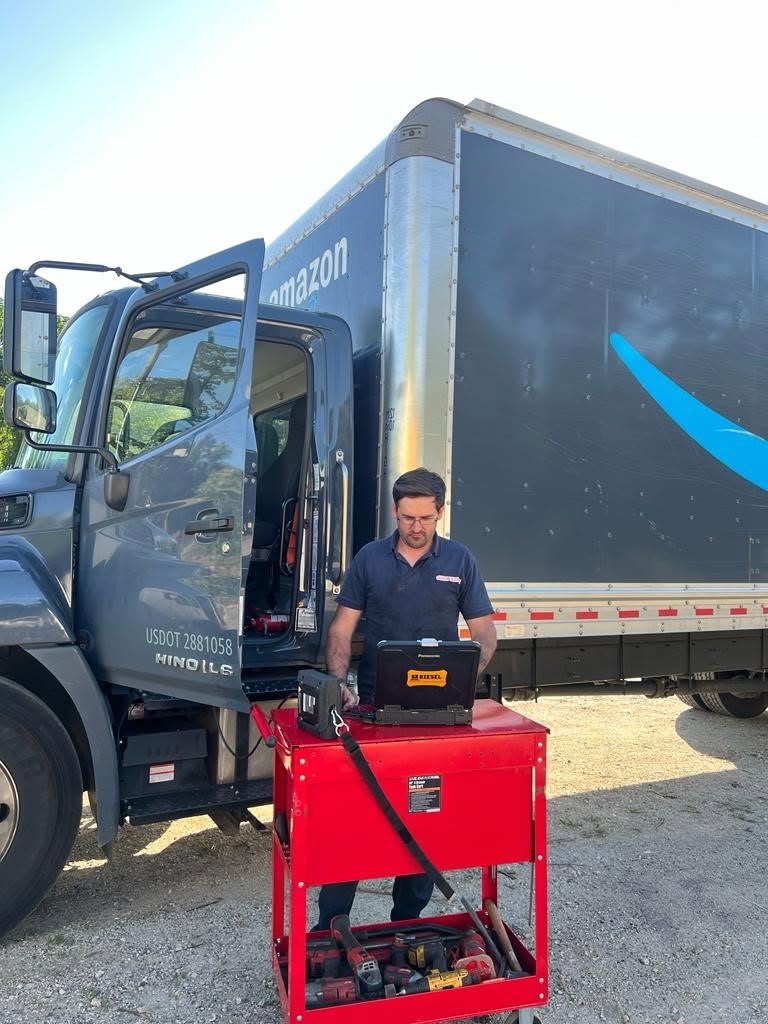 Technician running diesel diagnostics on a box truck