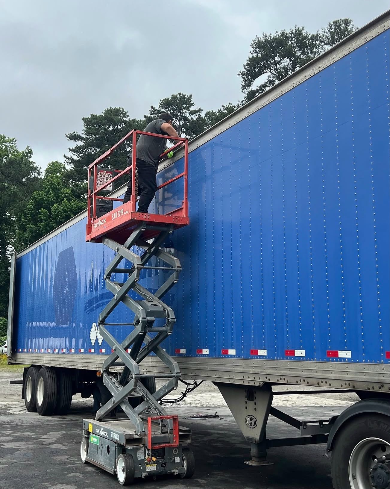 Trailer roof repair on a scissor lift